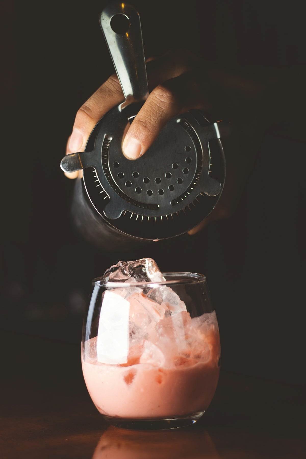a person pours a drink into a glass