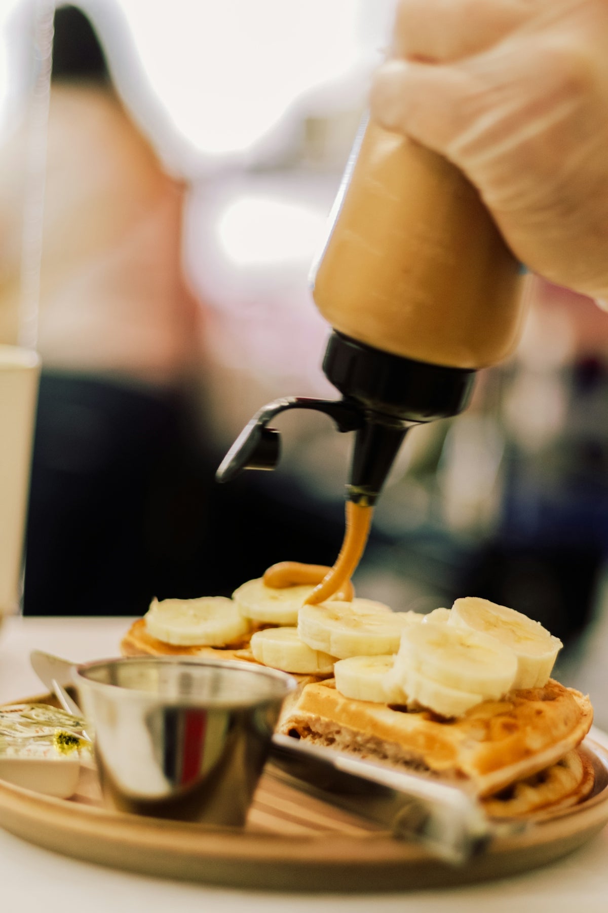 a person pouring syrup on a plate of food