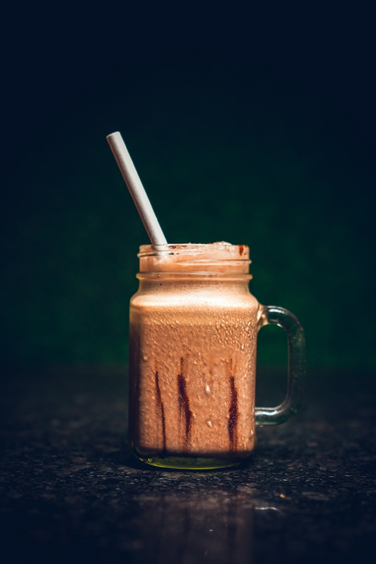 a glass with a straw in it sitting on a table