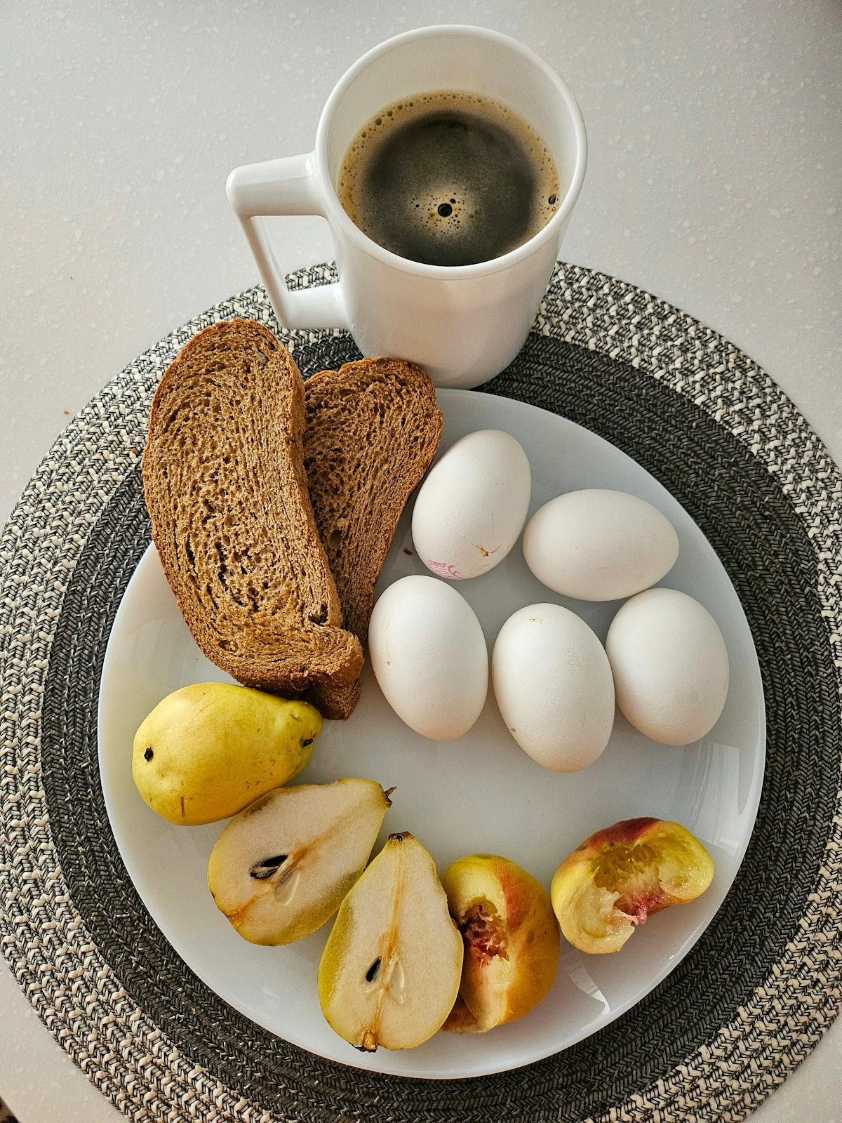 A white plate topped with sliced apples and a cup of coffee