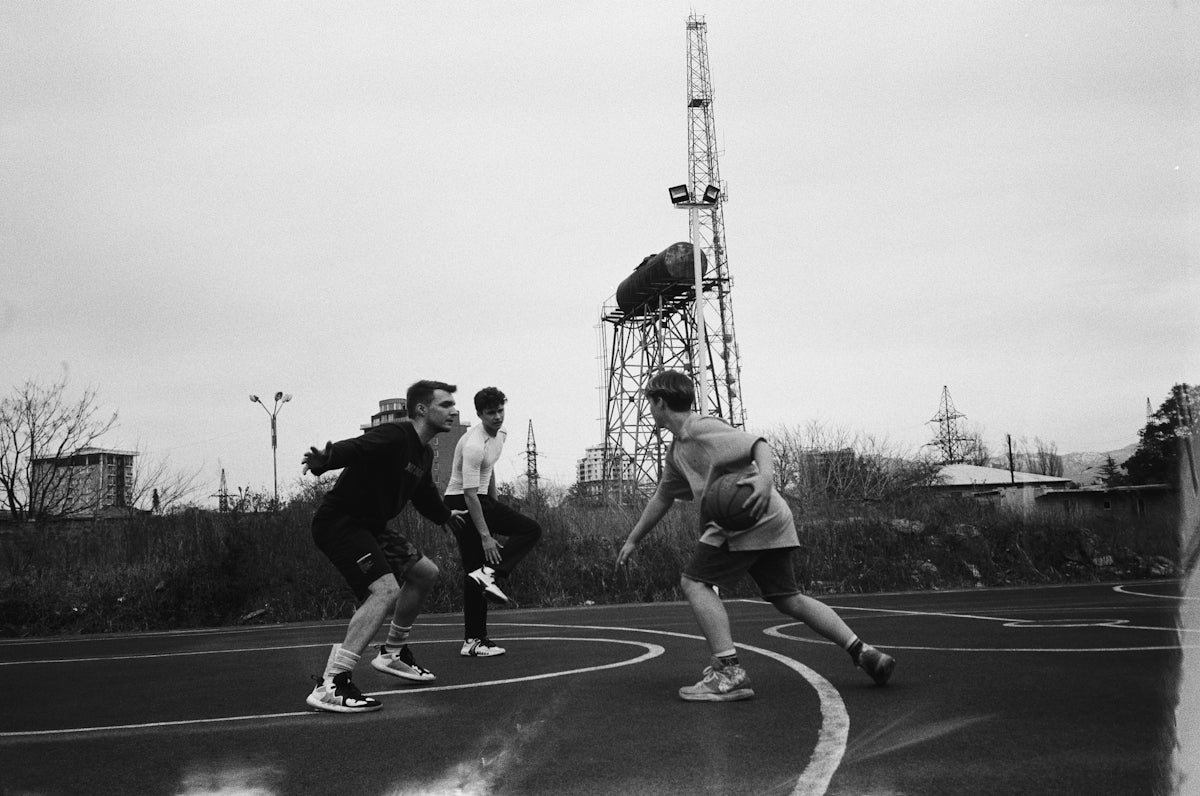 A group of young men playing a game of basketball